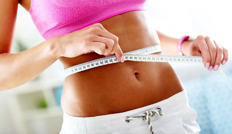 Woman measuring her waist at a spa